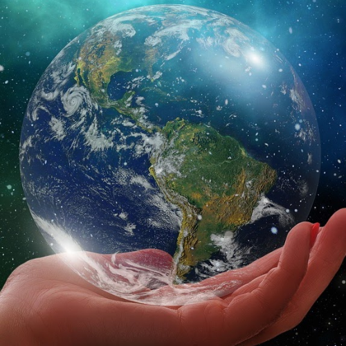 Hand holding a globe in space