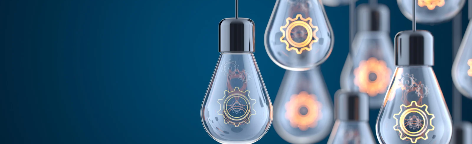 Lightbulbs with lit cogs hanging on black wires
